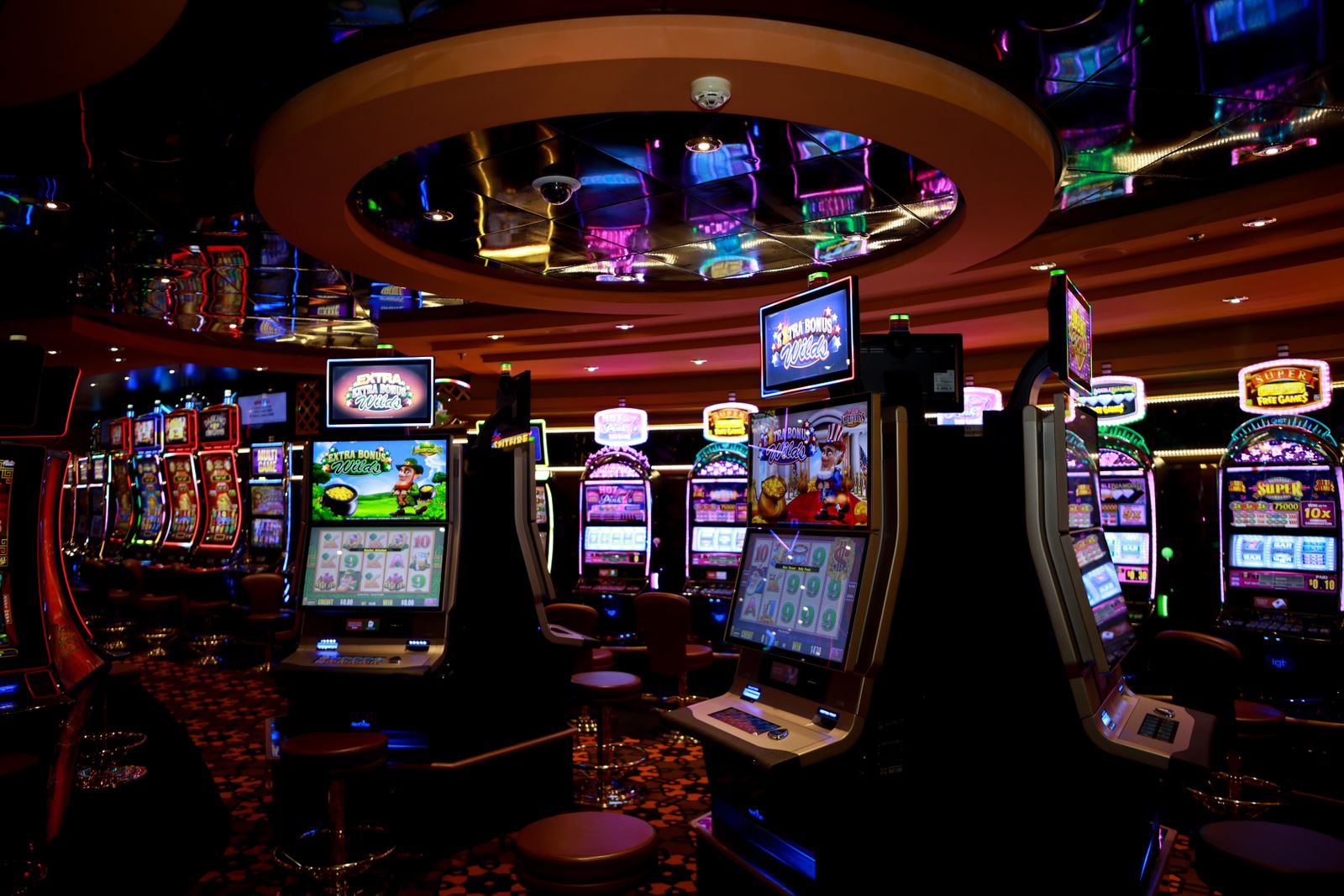 Casino floor with illuminated slot machines and gaming stations